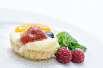 cream cake with strawberry apricot raspberries and blueberry on white plate, patisserie, sweet dessert, on-line shop photography