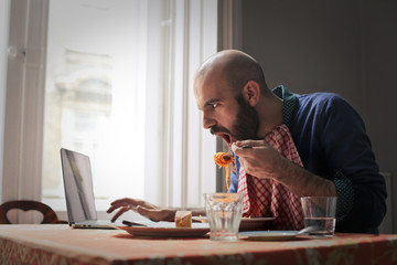 Man eating while surfing the Net