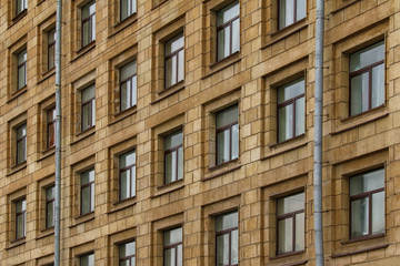 Many windows in row on facade of urban apartment building