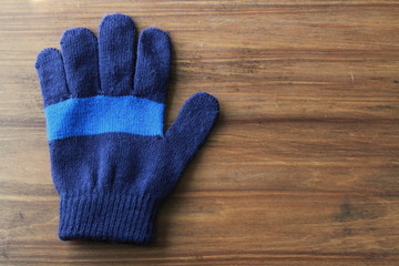 Kids Blue Striped Gloves on a wood background