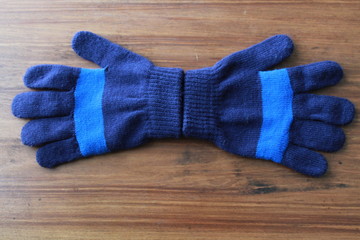 Kids Blue Striped Gloves on a wood background