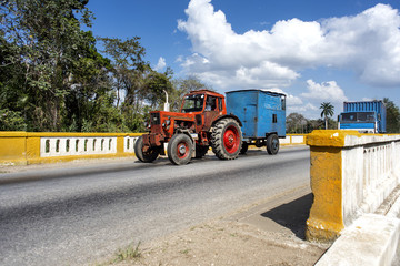 Kuba: Alter roter Traktor fährt mit Anhänger über eine traditionell gebaute kubanische Brücke - Transport © Rolf G. Wackenberg