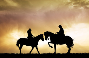 couple on horseback at sunset