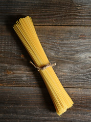 Bunch of spaghetti on wooden table background with copy space
