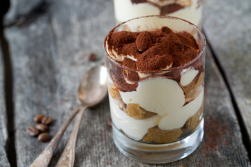 tiramisu in glass on wooden surface