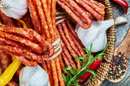 Cheese and chili snack stick sausages in a wooden basket