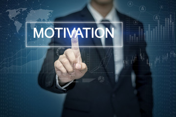 Obraz premium Businessman hand touching MOTIVATION button on virtual screen
