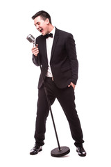 young man in suit singing over the microphone. Isolated on white background. Singer concept.