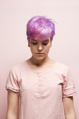 Violet-short-haired woman in pink pastel, with eyes closed.