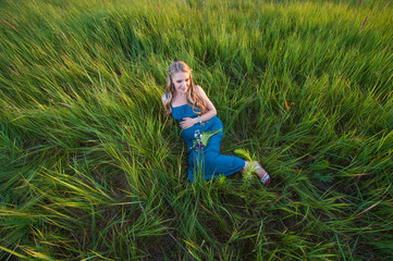 Fototapeta premium Smiling happy pregnant woman lying on the grass