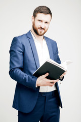 Young attractive bearded man in a business suit with a black boo