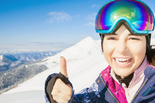 Happy girl dressed in ski or snowboard fashion mask goggles