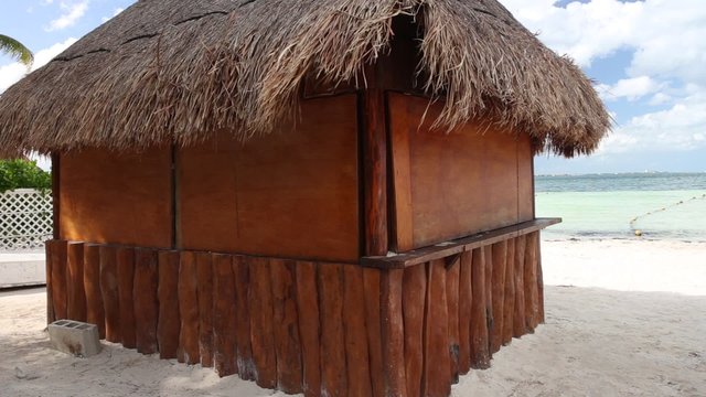 Tropical wooden hut with palm leafs roof on caribbean sea shore
