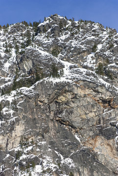 Tall Rock Face with Winter Snow and Icicles on Sunny Day
