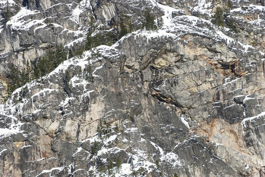 Texture Background of Mountain Rock Face with Snow and Icicles