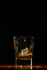 Whiskey splash in glass on black