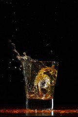 Whiskey splash in glass on black