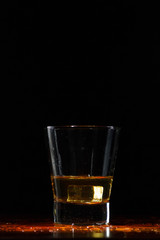Whiskey splash in glass on black