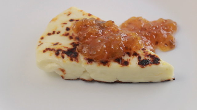 Rotating Lapland cheese with berry sauce on white plate