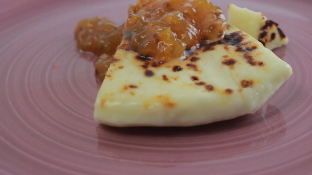 Lapland squeaky cheese with cloudberry jam on a pink plate