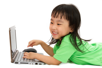 Chinese little girl lying down with laptop