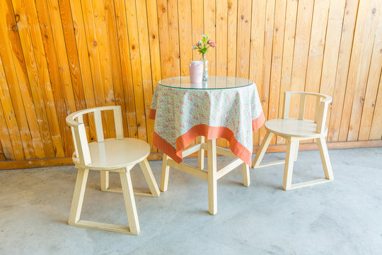 Outdoor table and two chairs near the wood wall at coffee shop,