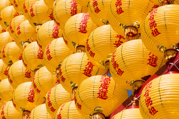 A wall of yellow Chinese rice lanterns in diagonal rows