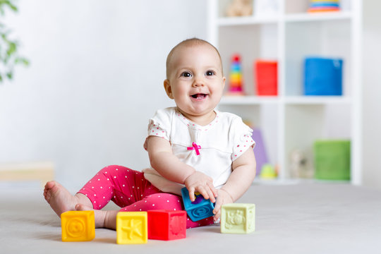 Baby girl playing cubes block toys