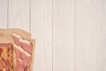Smoked meat on a white wooden table.