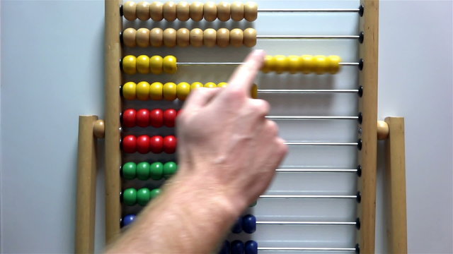 Man's hand moves the bones in the accounts of an abacus on white background