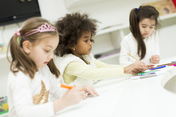 Multiracial children drawing in the playroom