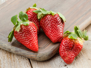 group of large strawberries on rustic kitchen table