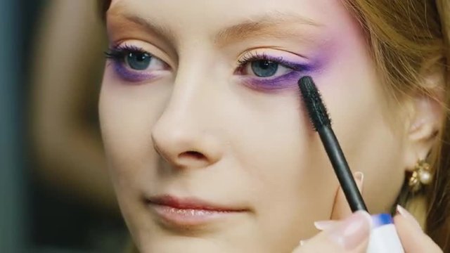 Young woman apply makeup to the eyelashes