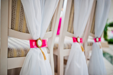 Wedding chairs with pink bow and brooch