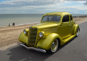 Fototapeta na wymiar Classic Gold vintage car in rally on Felixstowe seafront.