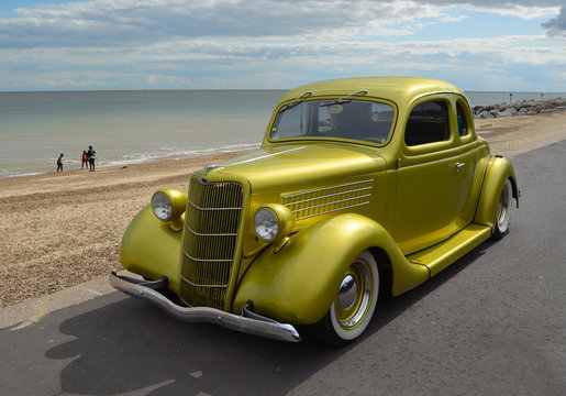 Fototapeta  Classic Gold vintage car in rally on Felixstowe seafront.