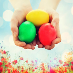 close up of kid hands holding colored eggs