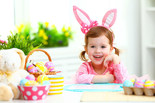 Easter. happy child girl with bunny ears with colored eggs and f