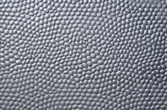 Black metal plate with bumpy surface