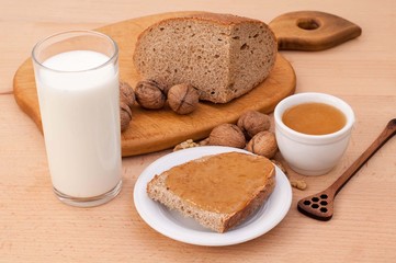 Slice of bread topped with honey, walnuts and milk