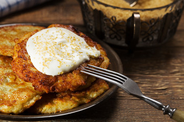 Homemade potato pancakes served with sour cream and brown sugar