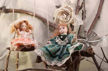 Porcelain dolls on swings photo. Two pretty porcelain dolls on swings photo. 