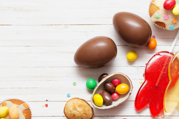 Chocolate Easter Eggs and Cupcake Over Wooden Background