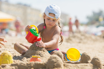 Four-year girl playing in the sand on beach seaside