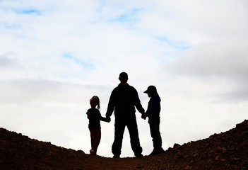 silhouette of father with two kids