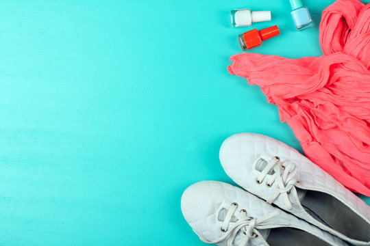 red scarf with shoes and nail varnish on a wooden table