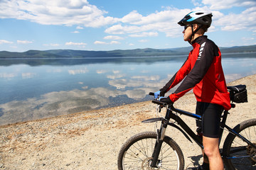 man with bike on a mountain lake