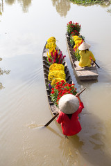 Vietnamese Woman with conical hat on a flower boat in SaDec