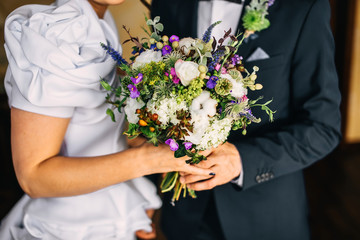 Groom hugs bride. bridal bouquet