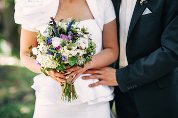 Obraz na płótnie Canvas Groom hugs bride. bridal bouquet